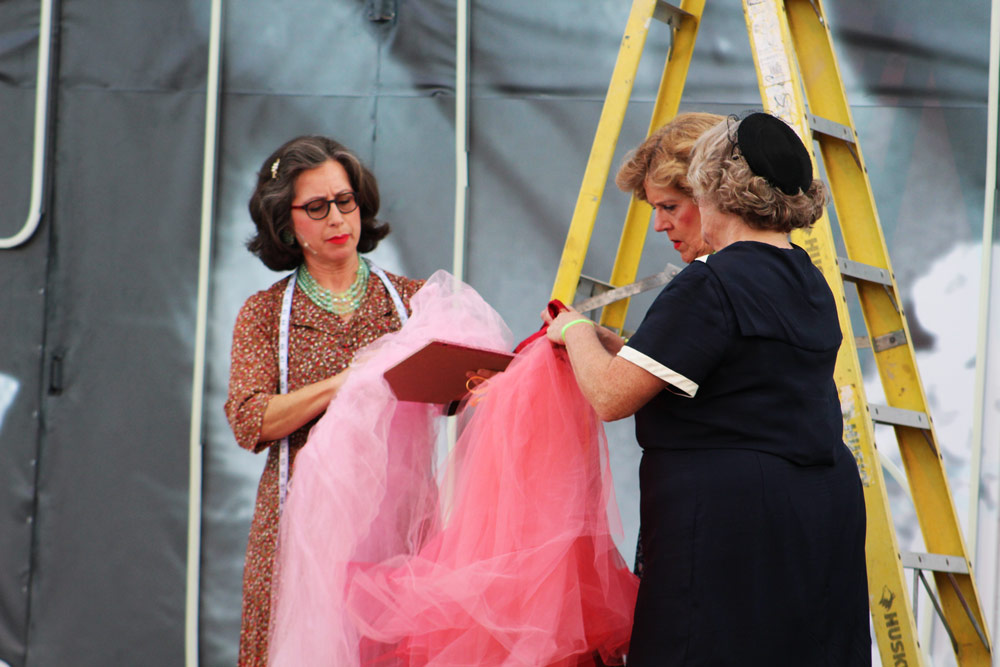 Three actors in our summer musical looking at Donated costumes and props to the Leawood Stage Company community theater near Kansas City